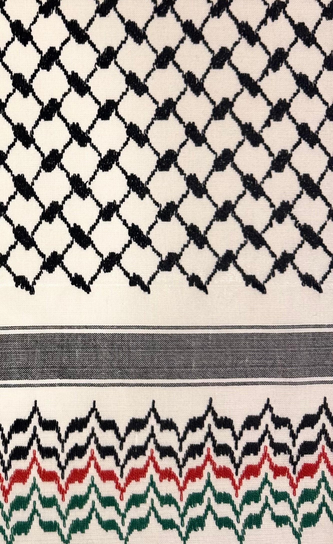 Nærbilde av tradisjonelt kufiyeh-mønster i palestinaflagg farger