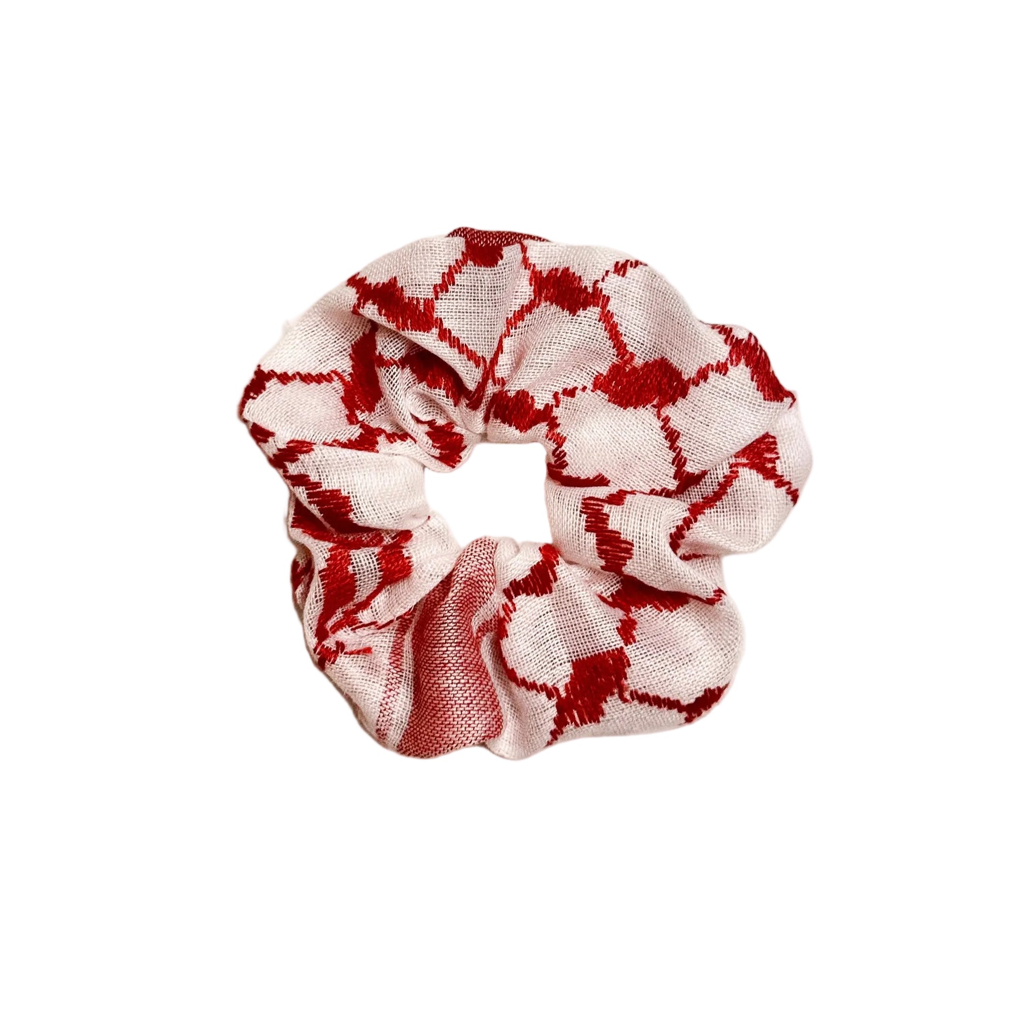 Rød og hvit scrunchie med kufiyeh-mønster, hårstrikk inspirert av tradisjonelt palestinsk design