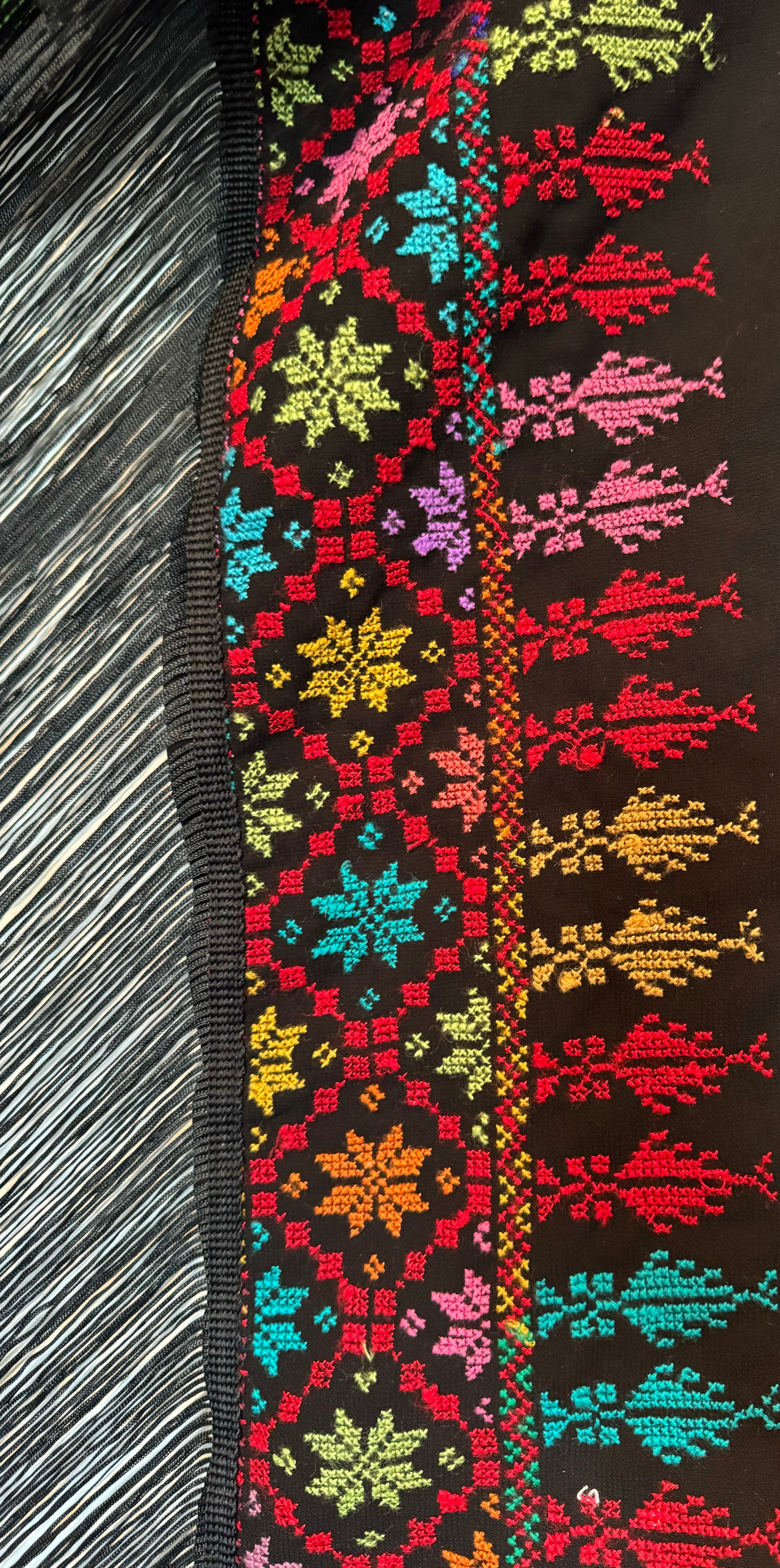 Detaljert tatreez-broderi på sjal, som viser variasjon i farger og sting.