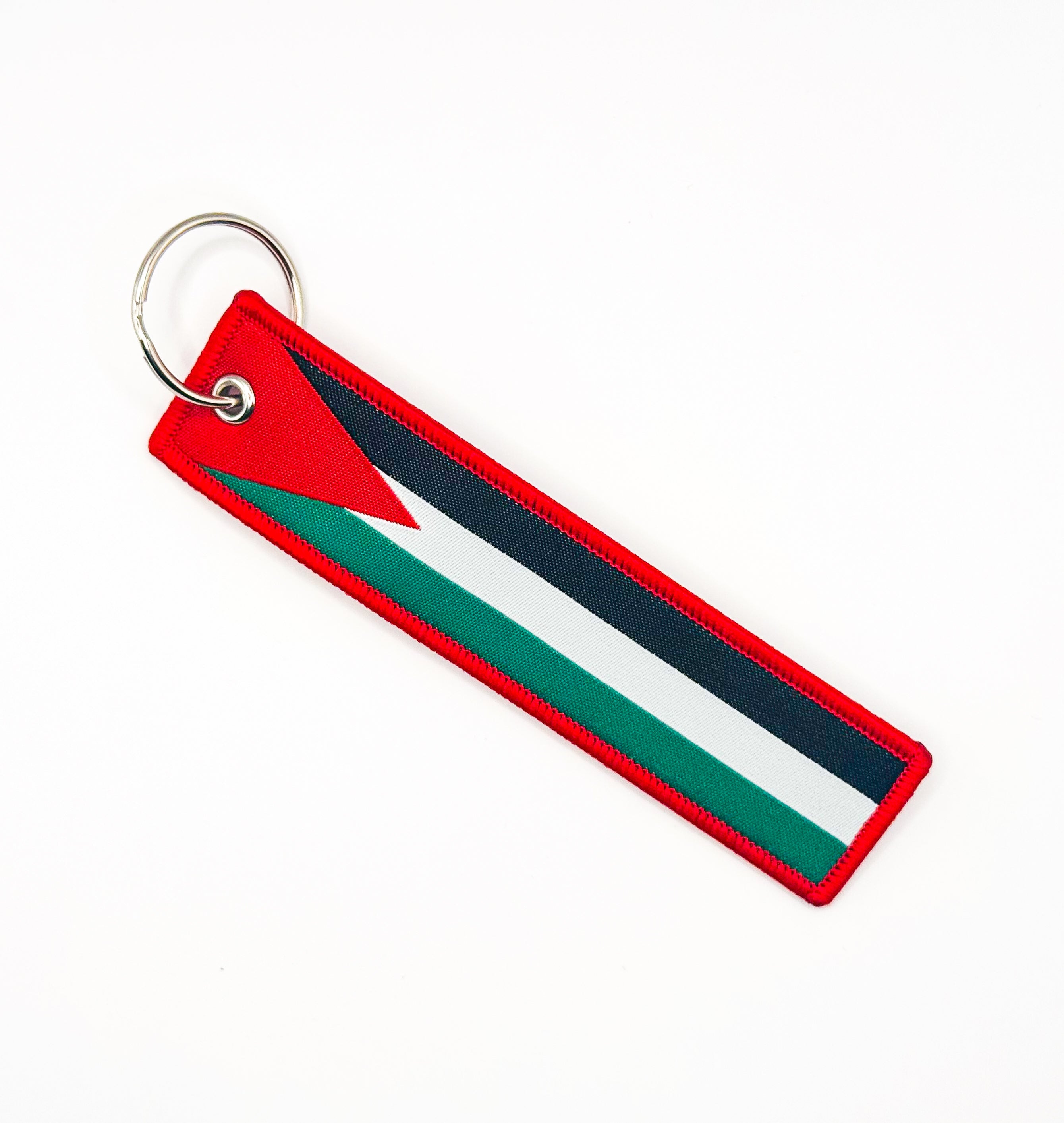Nøkkelring med palestinsk flagg i rødt, grønt, hvitt og svart, festet til metallring.
