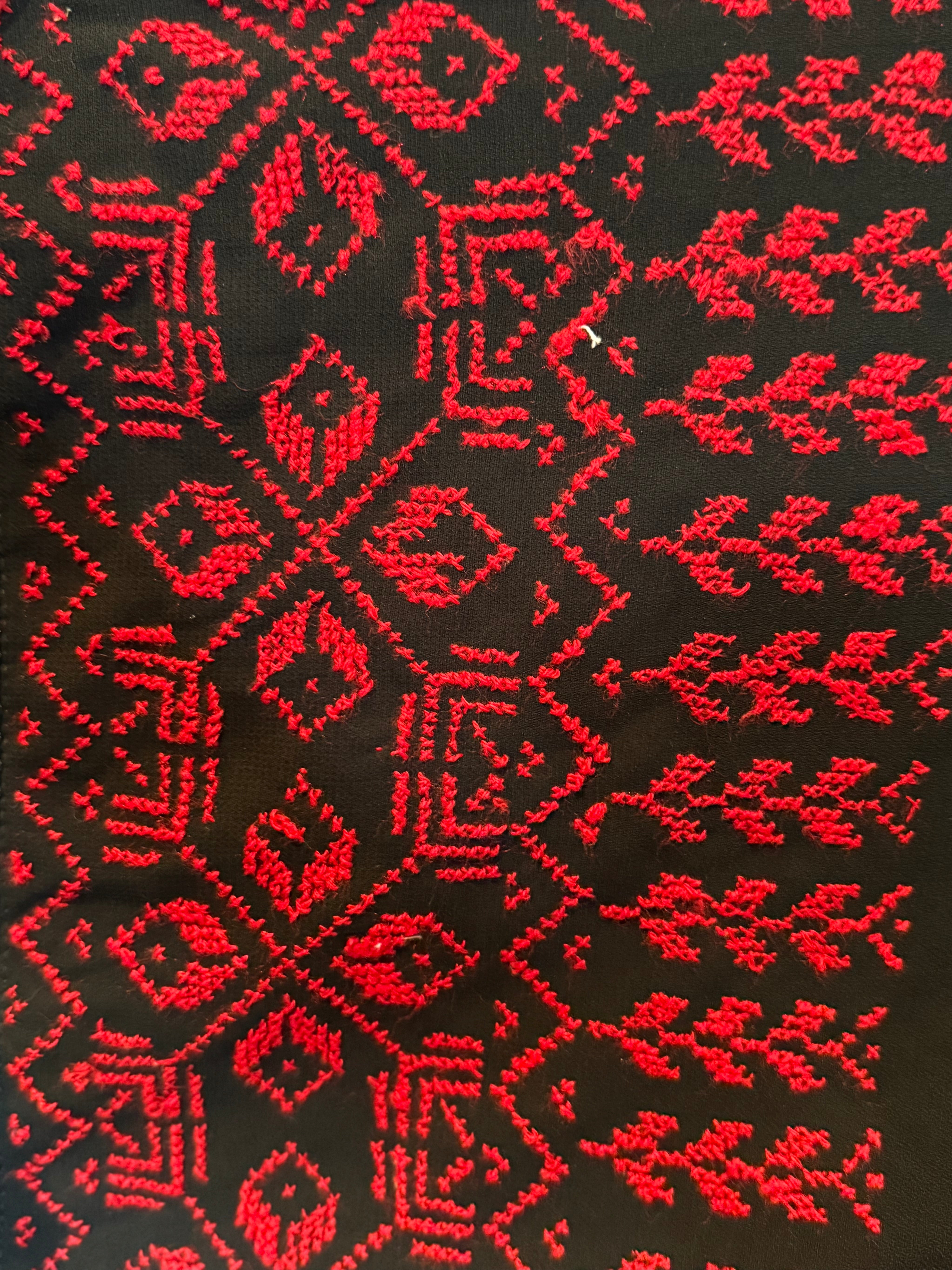 Brodert tatreez-detalj på et palestinsk sjal, der mønsteret følger stoffets lengde.