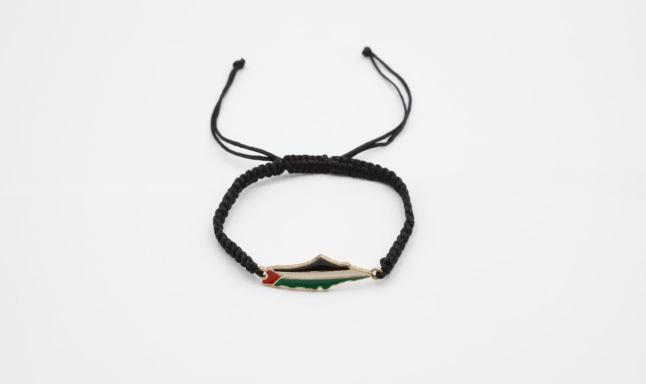 Horisontalt bilde av svart brodert armbånd med kartet av Palestina i mønsteret.