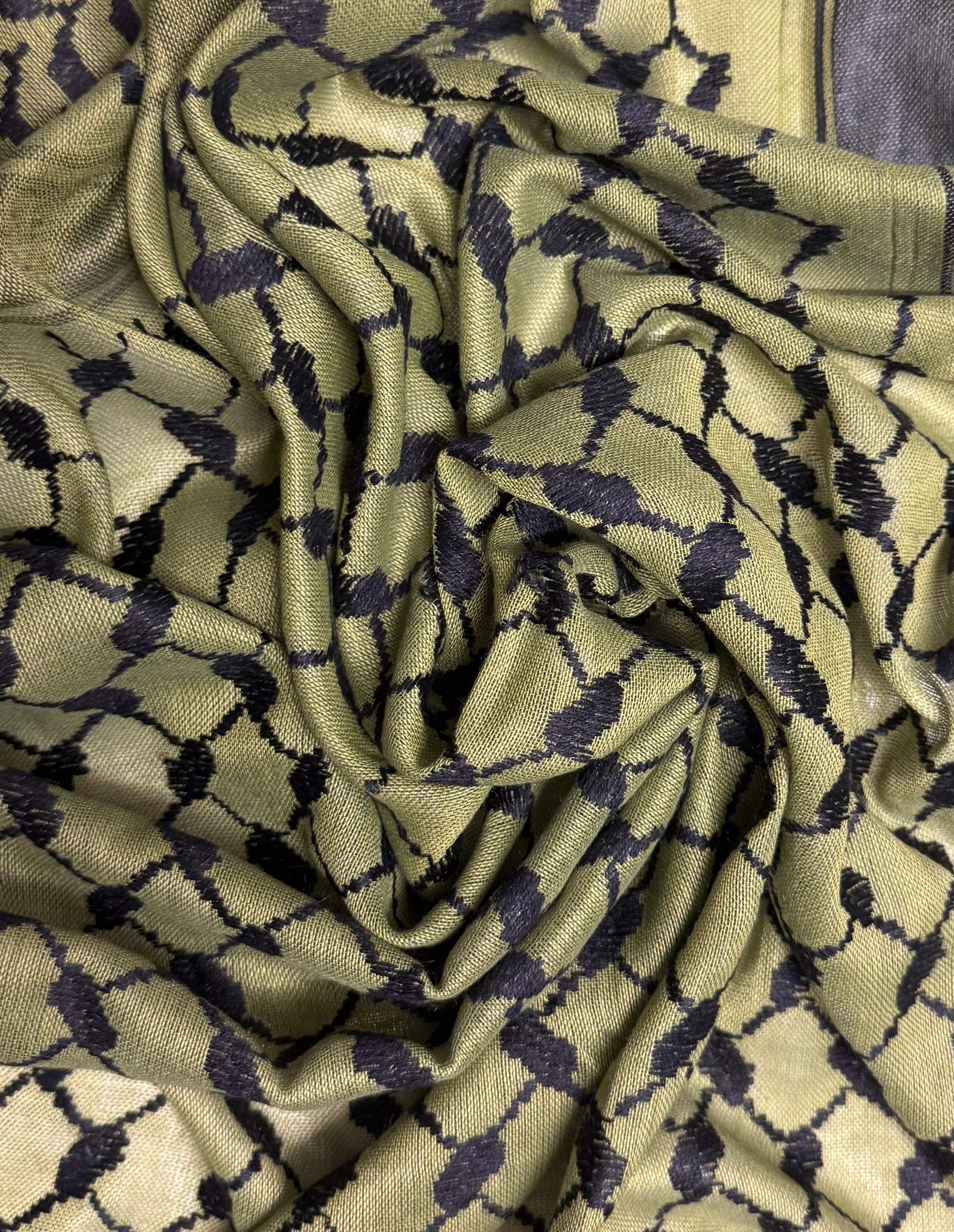 Nærbilde av kufiyeh-mønster i olivengrønne og svarte farger