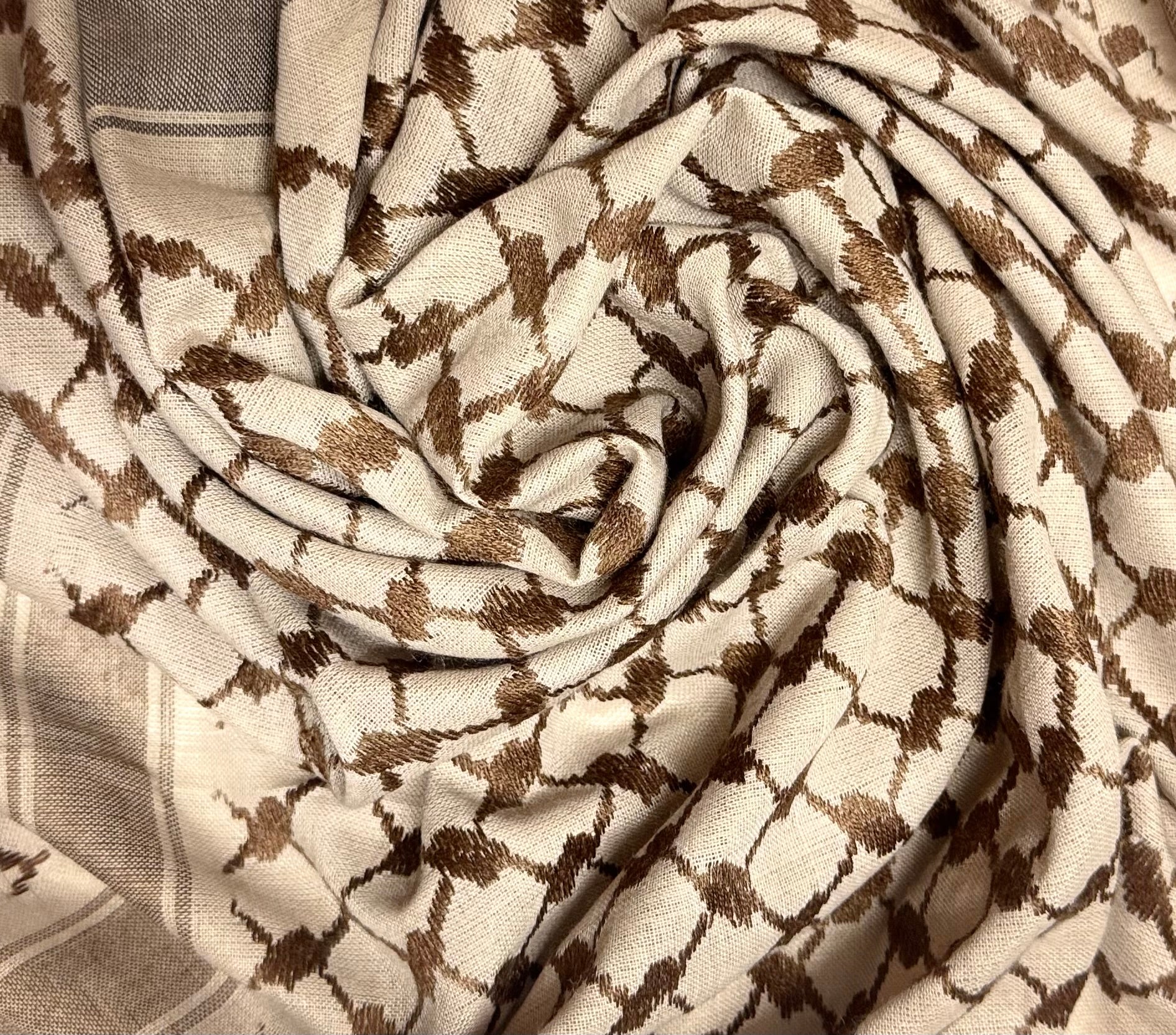 Nærbilde av kufiyeh-mønster i mørke brune farger