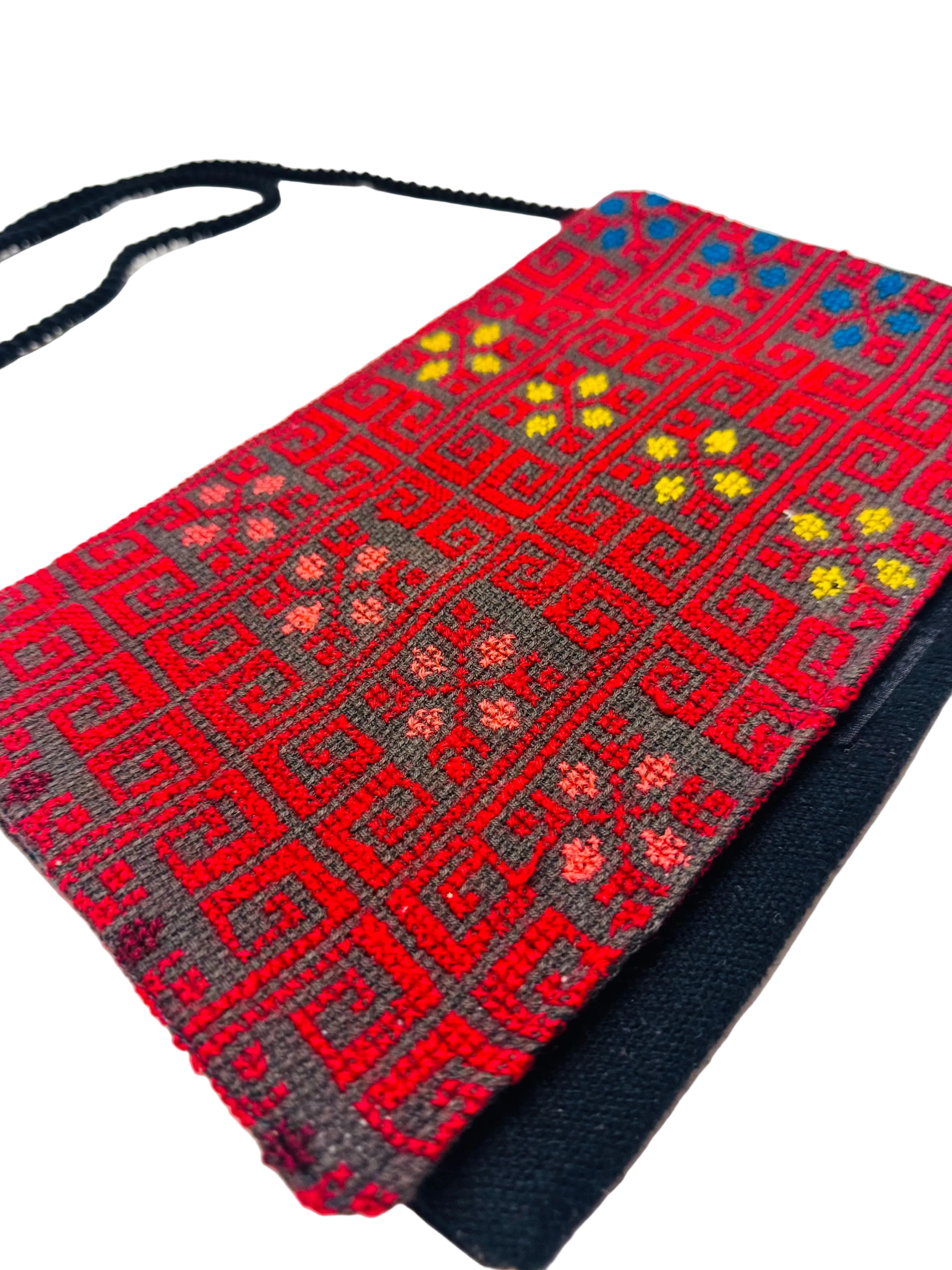Fargerik tatreez-veske fotografert fra skrå vinkel, med brodert mønster som gir dybde og karakter til designet.