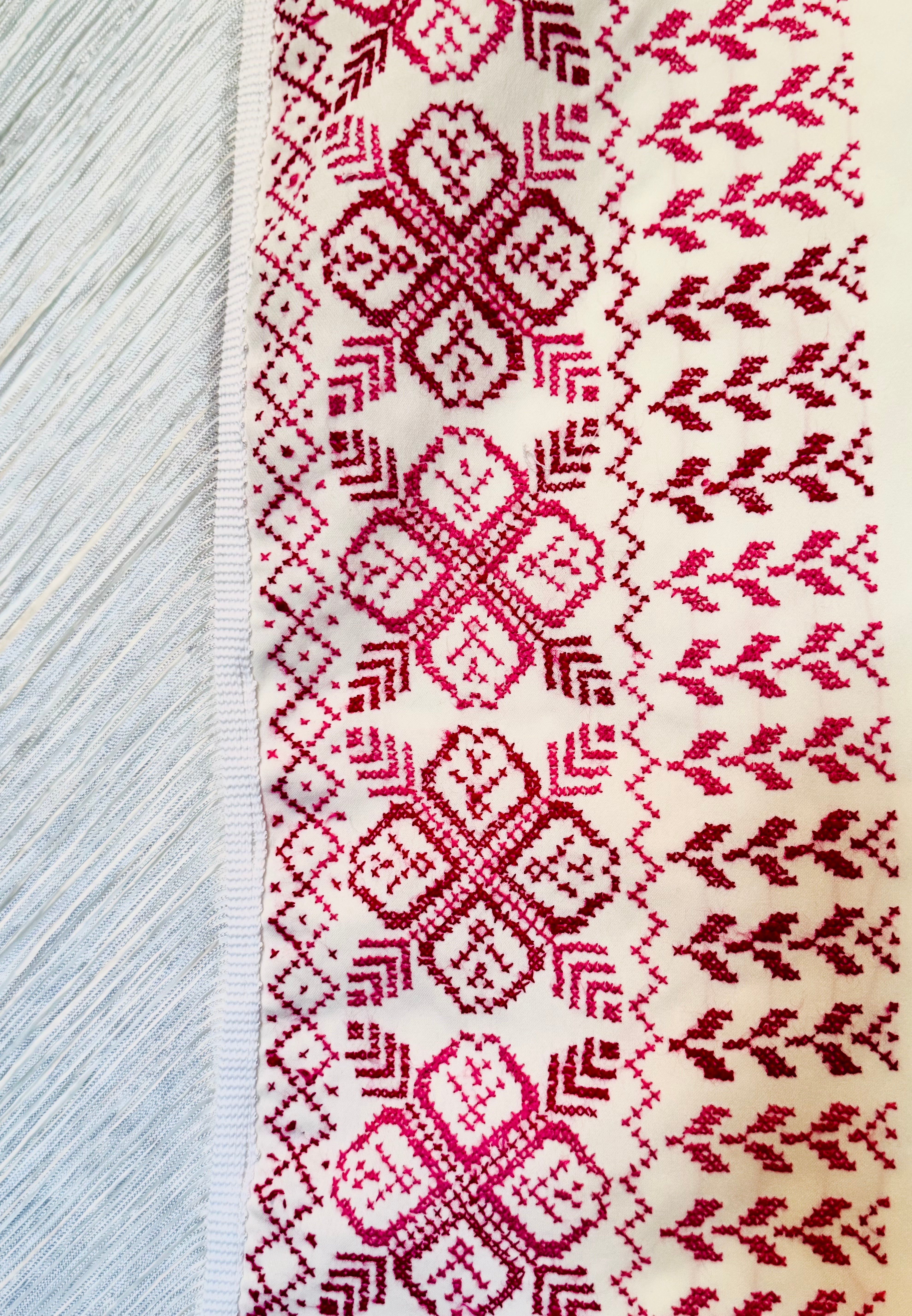 Makronærbilde av hvitt tatreez-sjal som fremhever palestinsk broderi og klassiske geometriske detaljer