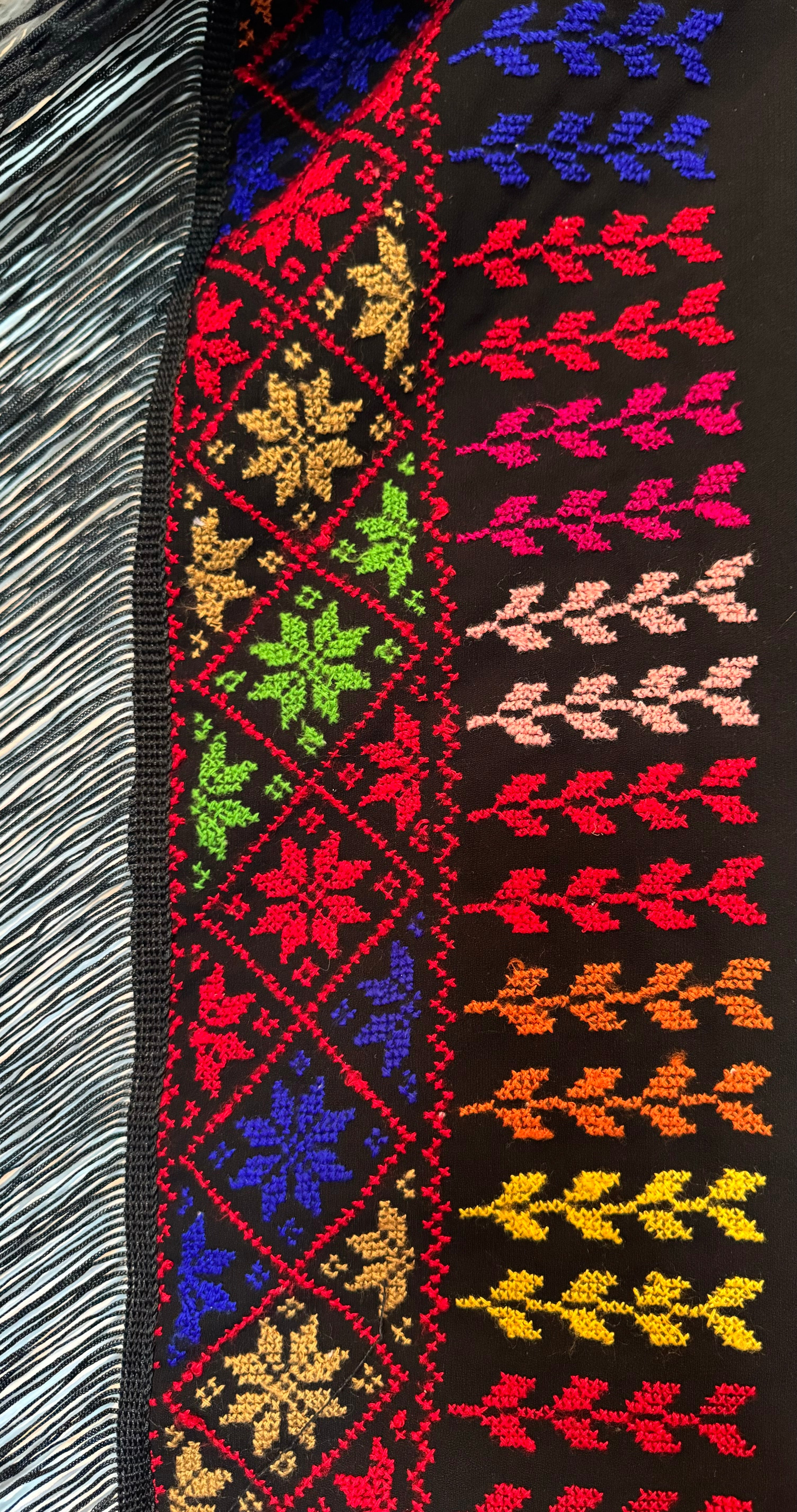 Brodert tatreez-detalj på skjerf, der mønsteret løper langs stoffets kant.