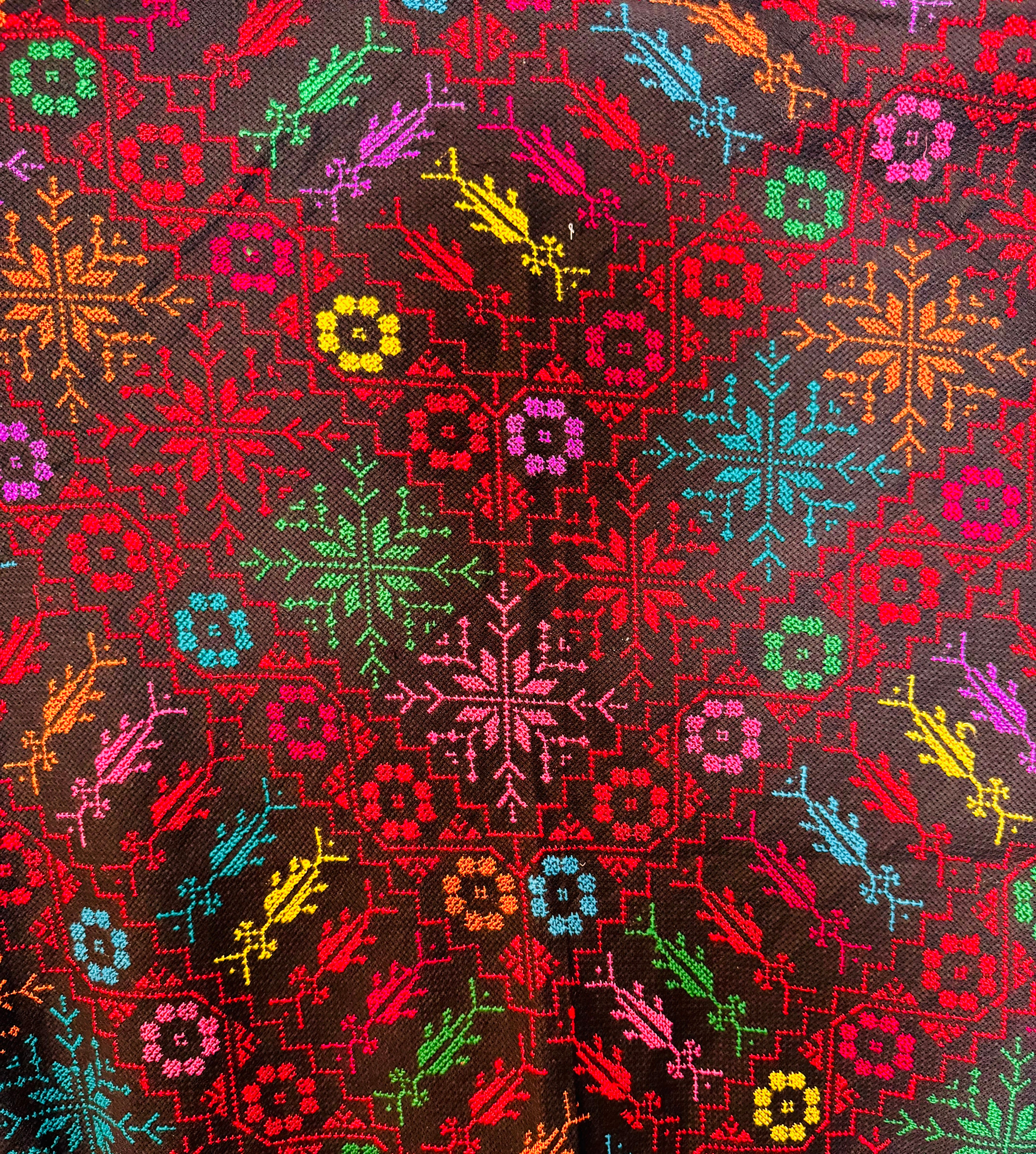 Makronærbilde av palestinsk tatreez-broderi som fremhever fargekontraster og klassiske geometriske motiver