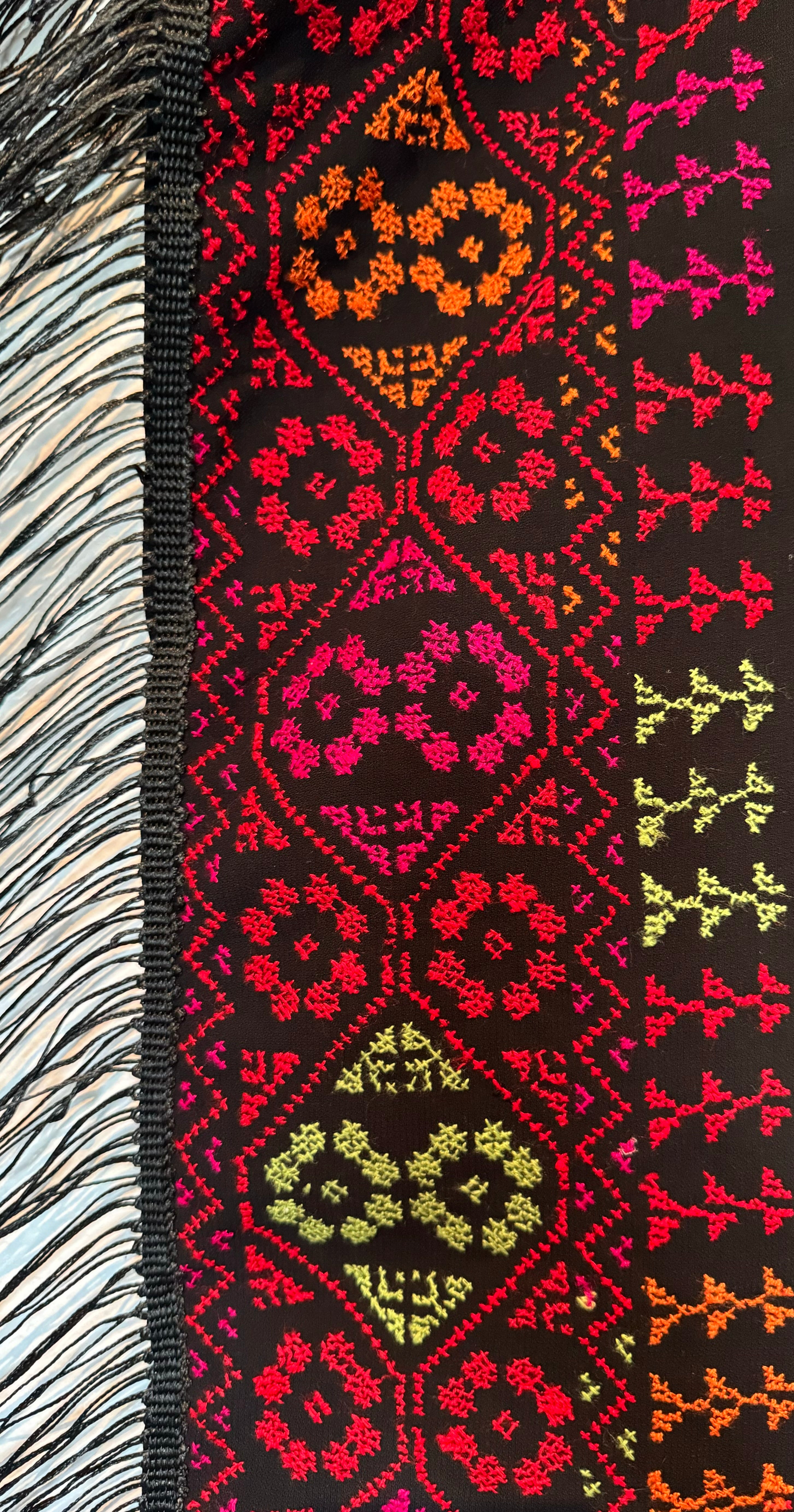 Tradisjonelt palestinsk tatreez-mønster brodert på et skjerf, med tydelig håndarbeid.